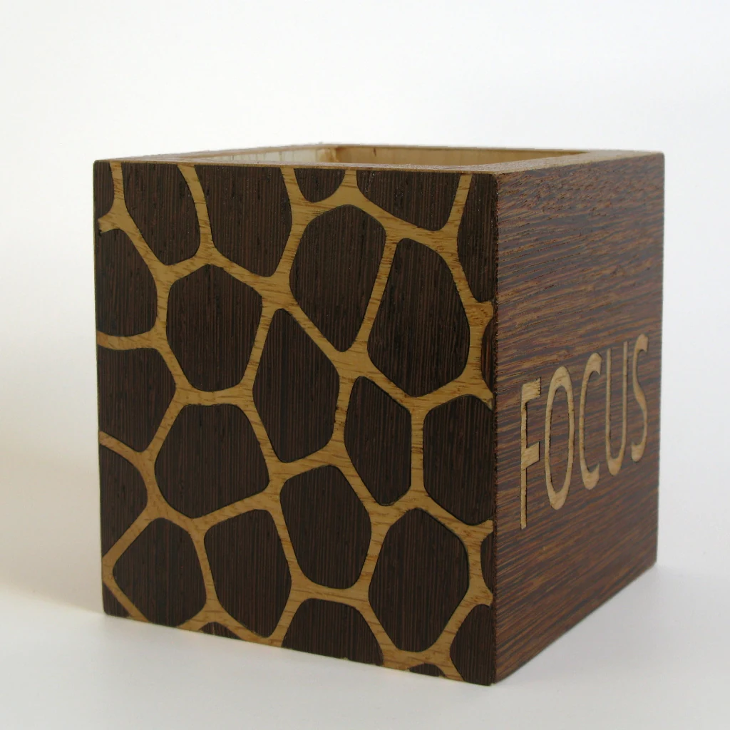 FOCUS Stiftehalter in Wenge und Eiche: Zellmuster auf der linken Flaeche, rechts der Schriftzug FOCUS in heller Eiche auf Wenge